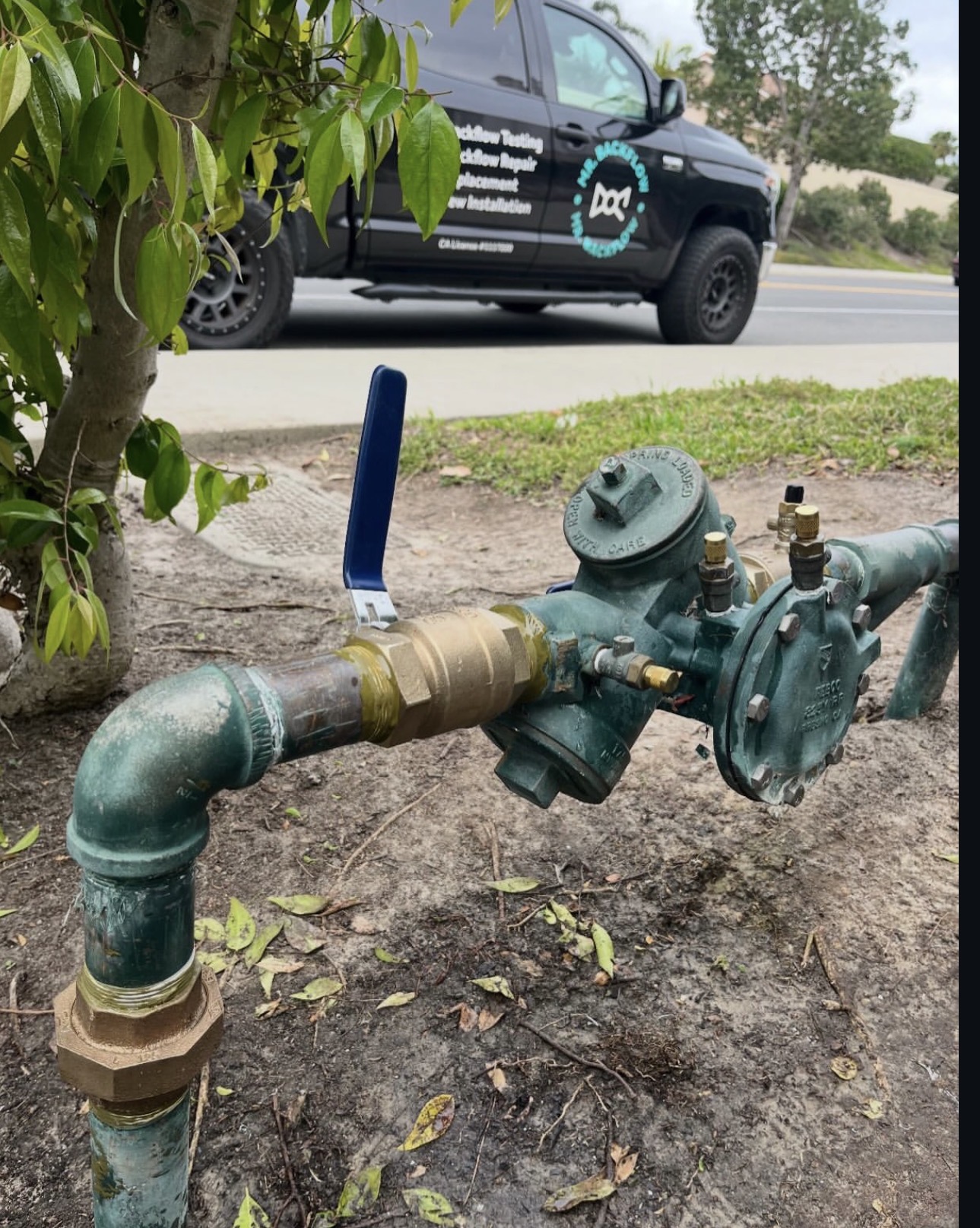 A backflow preventer with a Mr. Backflow service truck at a North County job site